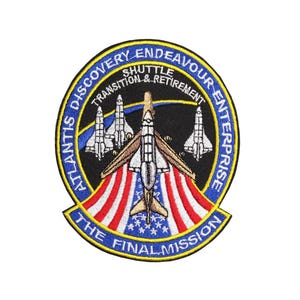 Op de afbeelding: Een blauw en wit geborduurde patch met de tekst "Atlantis Discovery Endeavour Enterprise Shuttle Transition & Retirement The Final Mission". De patch toont vijf spaceshuttles die in formatie vliegen boven een Amerikaanse vlag.