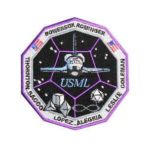 May include: A purple and white embroidered patch with the names of the crew members of the Space Shuttle mission STS-107: Bowersox, Rominger, Thornton, Sacco, Lopez-Alegria, Coleman, and Leslie. The patch also features a space shuttle, stars, and the mission's acronym, "USML".