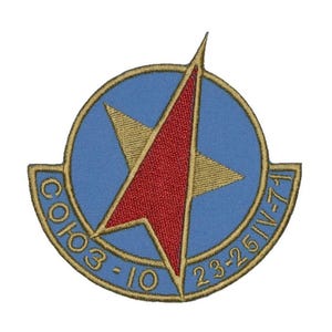 May include: A blue and gold embroidered patch with a red star in the centre. The text "CO103-10 23-26IV-71" is around the star.