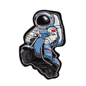 May include: An embroidered patch of an astronaut riding a blue scooter. The astronaut is wearing a white spacesuit with a black helmet and a red patch on the arm.