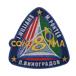 May include: A blue, green, and red triangular patch with a white star at each corner. The patch features the text "J. WILLIAMS", "M. PONTE", "СОЮЗ", "8", "ТМА", and "П.В. ВИНОГРАДОВ" in white and gold lettering.