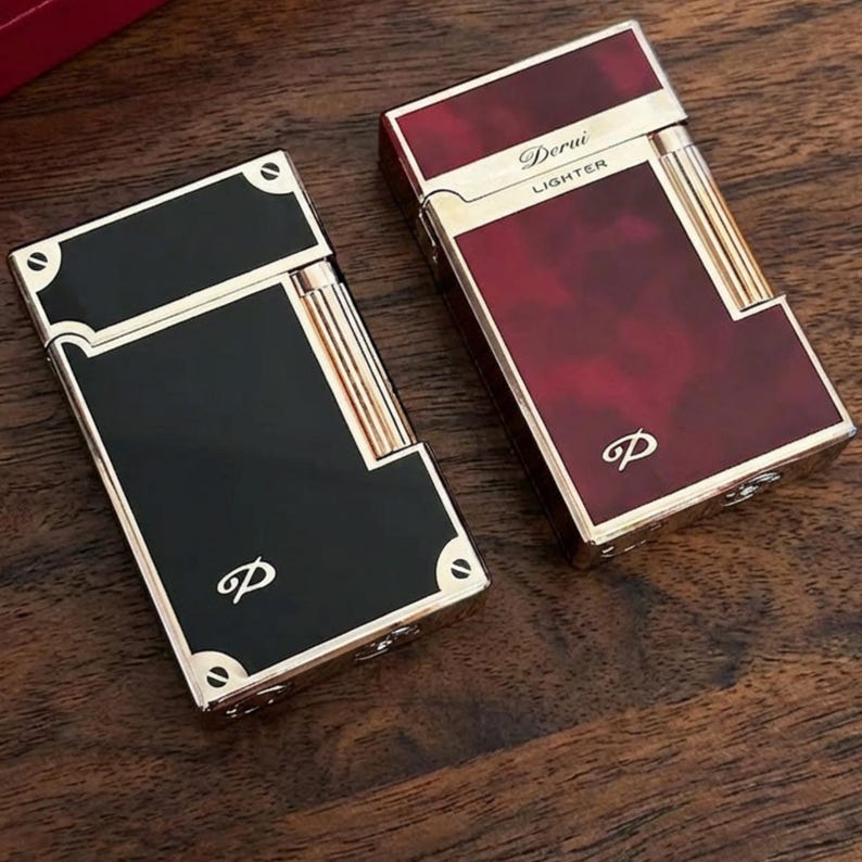 May include: Two rectangular lighters with gold detailing. One is black, the other is burgundy with a marbled pattern. Both feature the letter "p" and the burgundy lighter has the text "Derui LIGHTER".