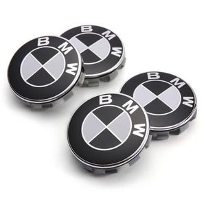 Puede incluir: Cuatro tapacubos de coche negros y plateados con el logotipo de BMW en el centro. El logotipo es un círculo blanco con un diseño de hélice negra en el interior.