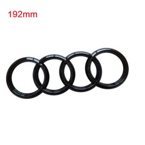Pode incluir: Emblema de carro de metal preto com quatro anéis entrelaçados. O emblema tem 192 mm de diâmetro.
