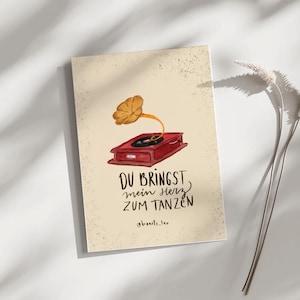 May include: A greeting card with a vintage gramophone illustration in red and gold. The card features the German phrase "DU BRINGST mein HERZ ZUM TANZEN" in black script, with the artist's name, "@beats_leo," below.