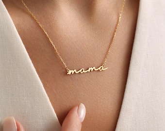 May include: A gold necklace with a cursive 'mama' pendant.