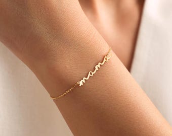 May include: A gold chain bracelet with the word "mama" written in cursive.