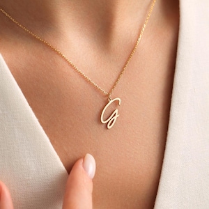 May include: A gold chain necklace with a cursive letter G pendant.