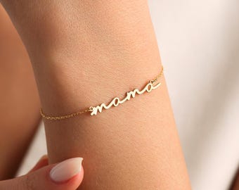 May include: A gold chain bracelet with the word "mama" written in cursive.