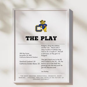 May include: A white framed print with a black and white image of a cartoon bear holding a football. The text "THE PLAY" is in bold black letters. The text below describes the 1982 Big Game between Stanford and California, with the final score of 20 to 25. The quote "THE MOST AMAZING, SENSATIONAL, DRAMATIC, HEART-RENDING... EXCITING, THRILLING FINISH IN THE HISTORY OF COLLEGE FOOTBALL!" is also included.