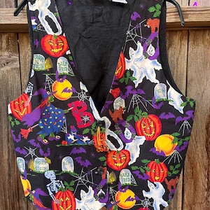 Vintage 90s Basic Editions Halloween Vest - Spooky Grannycore Print M/L A 90s vintage Basic Editions Halloween vest, featuring a playful all-over print with ghosts, pumpkins, skeletons, witches, and gravestones on a black background