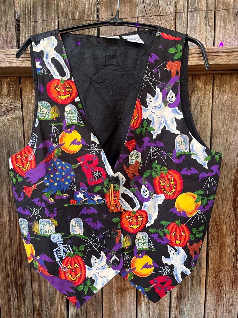 Vintage 90s Basic Editions Halloween Vest - Spooky Grannycore Print M/L A 90s vintage Basic Editions Halloween vest, featuring a playful all-over print with ghosts, pumpkins, skeletons, witches, and gravestones on a black background