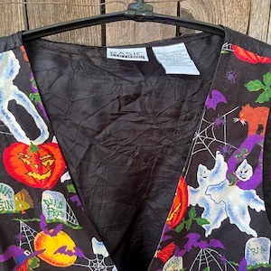 Vintage 90s Basic Editions Halloween Vest - Spooky Grannycore Print M/L A 90s vintage Basic Editions Halloween vest, featuring a playful all-over print with ghosts, pumpkins, skeletons, witches, and gravestones on a black background