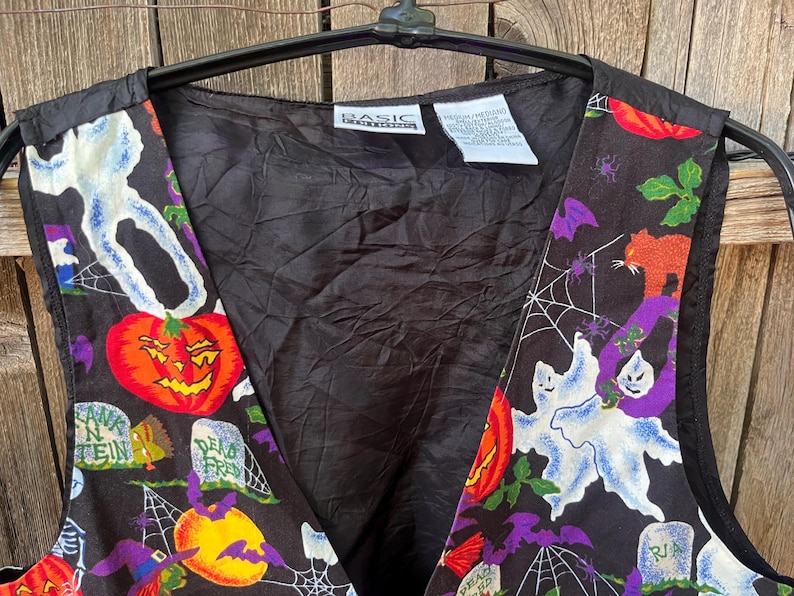 Vintage 90s Basic Editions Halloween Vest - Spooky Grannycore Print M/L A 90s vintage Basic Editions Halloween vest, featuring a playful all-over print with ghosts, pumpkins, skeletons, witches, and gravestones on a black background