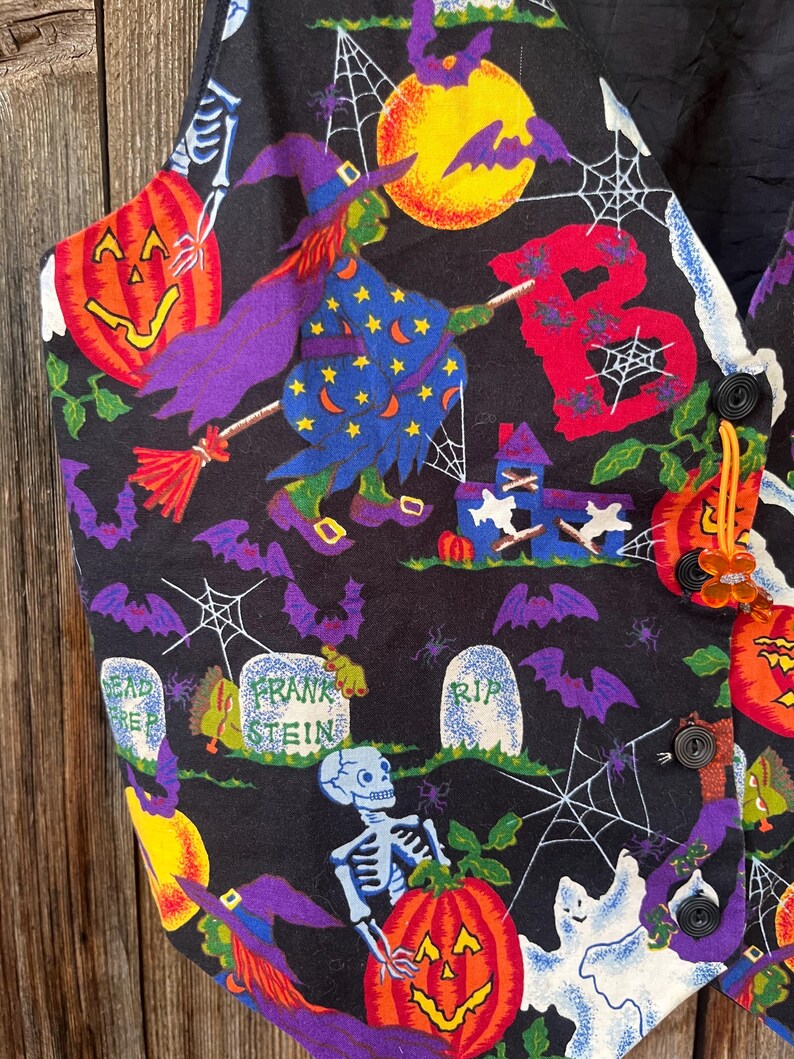 Vintage 90s Basic Editions Halloween Vest - Spooky Grannycore Print M/L A 90s vintage Basic Editions Halloween vest, featuring a playful all-over print with ghosts, pumpkins, skeletons, witches, and gravestones on a black background