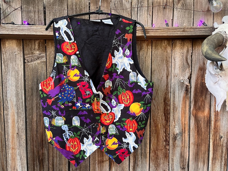 Vintage 90s Basic Editions Halloween Vest - Spooky Grannycore Print M/L A 90s vintage Basic Editions Halloween vest, featuring a playful all-over print with ghosts, pumpkins, skeletons, witches, and gravestones on a black background
