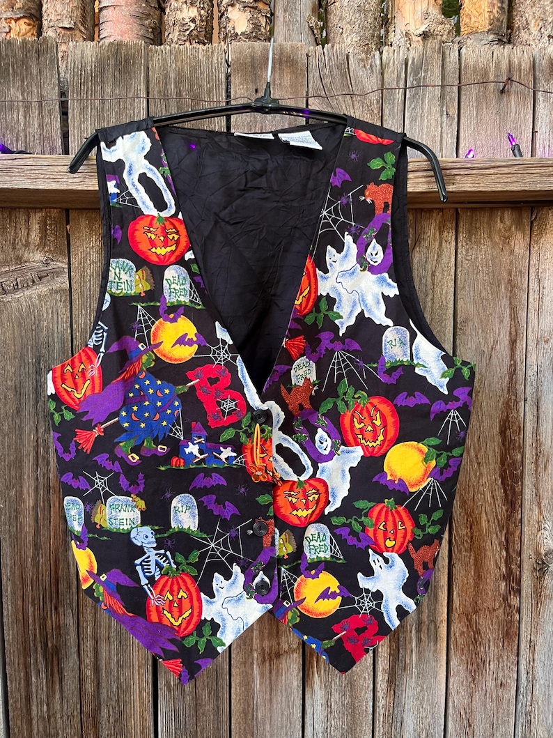 Vintage 90s Basic Editions Halloween Vest - Spooky Grannycore Print M/L A 90s vintage Basic Editions Halloween vest, featuring a playful all-over print with ghosts, pumpkins, skeletons, witches, and gravestones on a black background