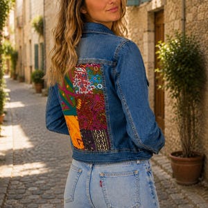 Peut inclure: Une veste en jean bleu avec un grand panneau arrière rectangulaire composé de tissus patchwork multicolores aux motifs floraux et cachemire, associée à un jean en denim bleu clair doté d'une petite étiquette de marque rouge sur la poche arrière.