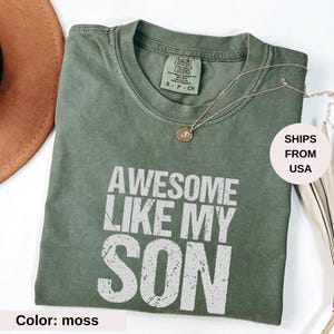 Peut inclure: Un t-shirt vert avec le texte "Awesome Like My Son" en lettres blanches vieillies. Le t-shirt est fait d'un tissu doux et confortable et a une coupe décontractée.