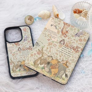 May include: A phone case and a book cover with a floral pattern and Winnie the Pooh characters. The phone case has a black border and the book cover has a white border. The text on the book cover reads "Sometimes the smallest things take up the most room in your heart."