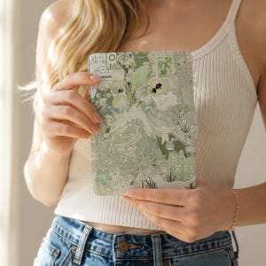 May include: A rectangular e-reader or tablet case featuring a collage of various green-toned illustrations, including stylised figures, floral patterns, and small creature motifs, all rendered in a monochromatic light and sage green colour palette.