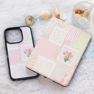 May include: Two phone cases with a patchwork design featuring pink and white floral patterns and pink tulips. The cases are made of a hard plastic material and have a glossy finish.