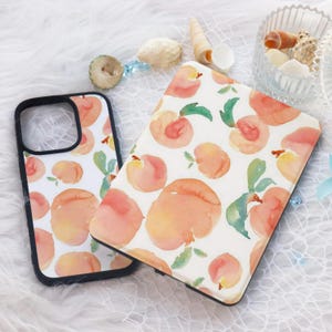 May include: Two phone cases with a watercolor peach pattern. The cases are black with a white background and feature peach illustrations.