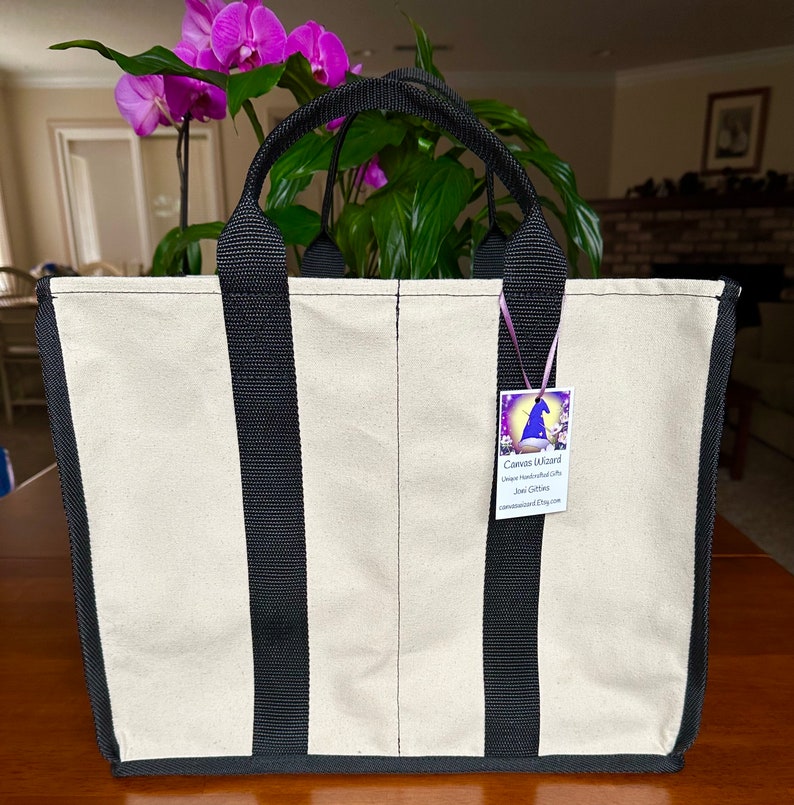 May include: A natural canvas tote bag with black straps.
