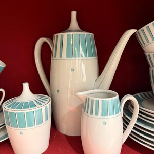 Könnte beinhalten: Ein Vintage-Tee-Set mit einem geometrischen Muster in Teal und Weiß. Das Set enthält eine Teekanne, eine Milchkännchen, eine Zuckerdose und Untertassen.
