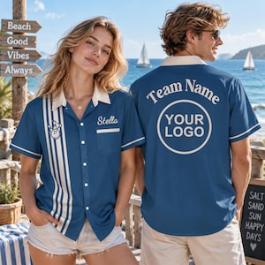 May include: A blue button-down bowling shirt with a cream collar and vertical stripes on the front. The front features a bowling pin graphic and the name Stella. The back displays the text Team Name and a circular logo with YOUR LOGO.