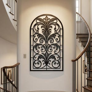 Peut inclure: Une grande pièce d'art mural en métal noir en forme d'arche, présentant un design découpé complexe et symétrique avec des volutes et des motifs de feuilles. Le panneau décoratif est fixé sur un mur blanc incurvé entre deux escaliers en bois.