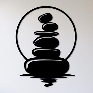 Pu&ograve; includere: Arte da parete in metallo nero raffigurante una pila di pietre lisce, che simboleggia equilibrio e serenit&agrave;. Le pietre sono racchiuse in una cornice circolare, con un effetto di riflesso alla base. Design minimalista.
