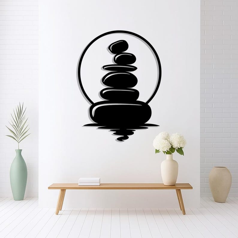 Pu&ograve; includere: Arte da parete nero raffigurante una pila di pietre lisce all'interno di una cornice circolare, creando un'atmosfera zen. Le pietre si riflettono nell'acqua sottostante, aggiungendo profondit&agrave; al design. Ideale per un tocco di calma.