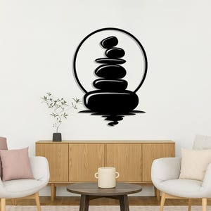 Pu&ograve; includere: Silhouette nera di pietre zen impilate, su sfondo bianco. Le pietre sono all'interno di un cerchio nero, con un riflesso sottostante. Un design minimalista per l'arredamento della casa.