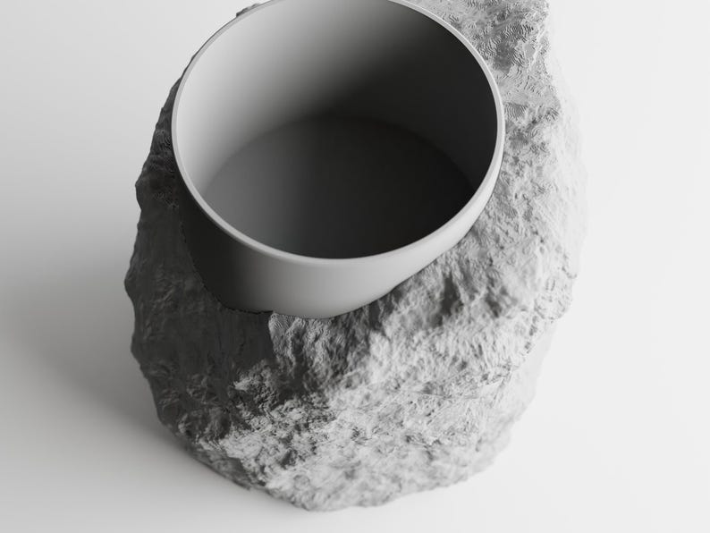 May include: A gray ceramic planter shaped like a rock with a smooth, round, gray ceramic bowl on top.