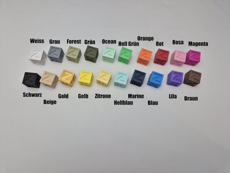 May include: A collection of small, cube-shaped objects in various colors, each with a letter "Z" on one side. Colors include white, gray, forest green, ocean blue, orange, red, pink, and magenta, with text labels in German.