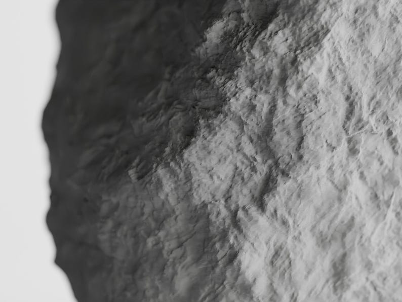 May include: A close-up of a textured, gray rock surface. The surface is rough and uneven, with a variety of shades of gray.