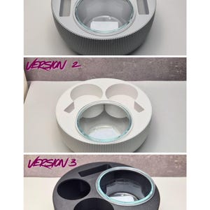 May include: A set of three round serving trays in different colors: gray, white, and black. Each tray has a central glass bowl and various compartments for holding items. The text "VERSION 1", "VERSION 2", and "VERSION 3" is visible.