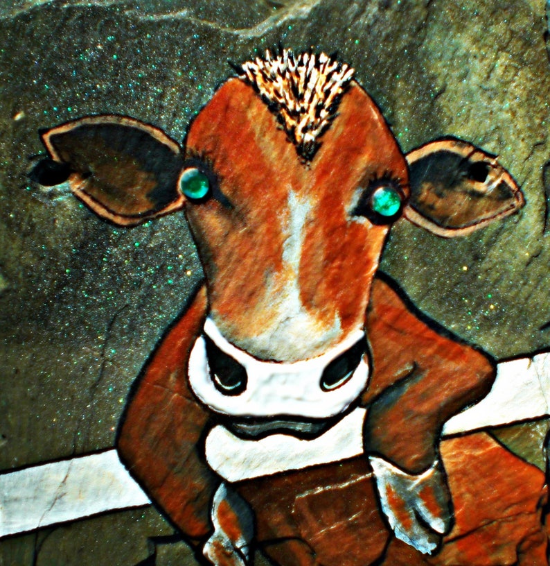 May include: A hand-painted cow with brown and white fur, green eyes, and a spiky brown mohawk. The cow is painted on a textured, green background.