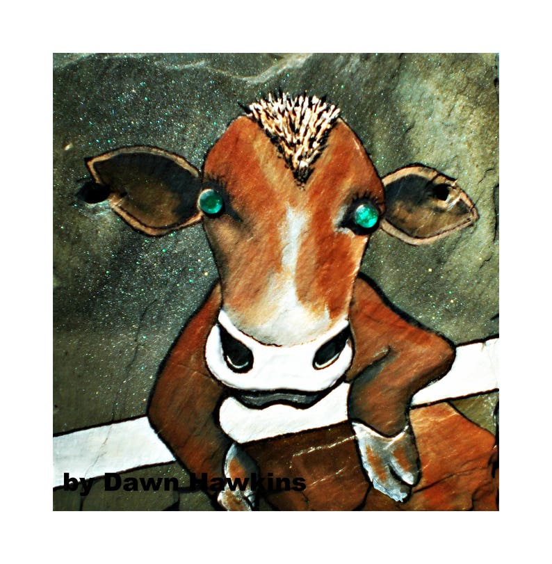 May include: A brown and white cow with green eyes looks directly at the viewer. The cow is painted on a textured, dark green background with glitter.