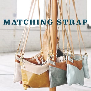 May include: Five different colored leather crossbody bags with matching straps hanging from a wooden rack. The bags are all different colors and styles, but they all have the same strap. The text "MATCHING STRAP" is displayed at the top of the image.