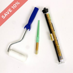 May include: A set of three painting tools: a blue handled mini roller, a green handled paint brush, and a black clip-on stencil level in a clear plastic tube. The tube has the text "Clip-on Stencil Level" printed on it.