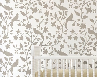 May include: A white wall with a repeating pattern of brown birds and branches. The pattern is a stencil design. A white crib is in the foreground.