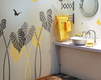May include: A bathroom with a white sink and a towel rack. The wall is decorated with a stencil of tropical leaves and butterflies in shades of gray and yellow.