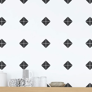 May include: A white wall with a repeating pattern of black diamond shapes. The wall is decorated with black and white patterned mugs and clear glass cups.