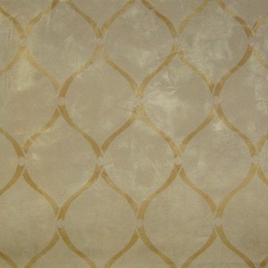 May include: A beige fabric with a repeating pattern of gold-colored, curved lines forming a lattice design.
