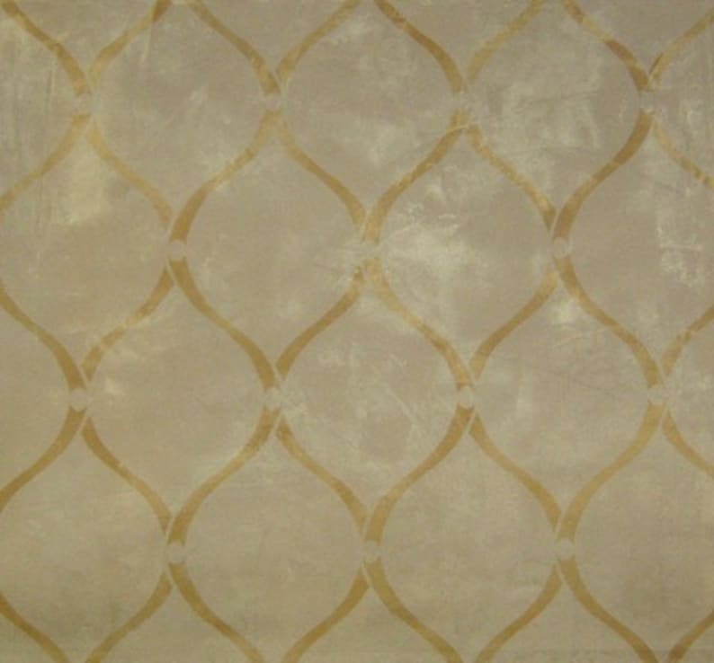 May include: A beige fabric with a repeating pattern of gold-colored, curved lines forming a lattice design.