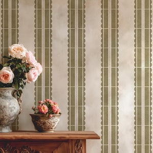 May include: An interior scene with a wooden table holding a vase of pink roses and a small floral arrangement. The background features a wallpaper design with vertical olive green and white scalloped stripes, creating a vintage aesthetic.