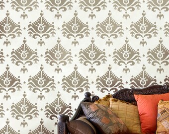 May include: A brown couch with a patterned fabric and several cushions. The couch is in front of a wall with a brown and white damask pattern.