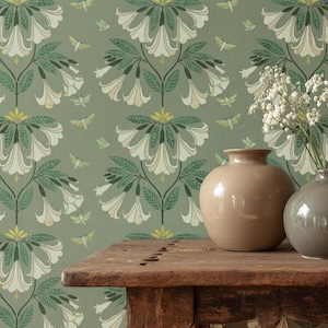 May include: A still life featuring two ceramic vases on a rustic wooden table. The background is a green wallpaper with a repeating pattern of white flowers, green leaves, and small insect illustrations. One vase is beige, the other is gray.